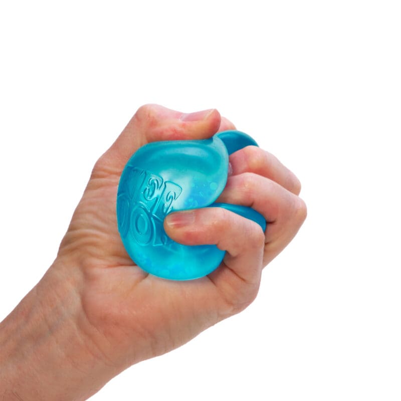 DRDND_Image3 A hand is squeezing a blue sensory toy against a white background. The NeeDoh toy has some texture and appears slightly translucent. The fingers are wrapped tightly around it, indicating a firm grip.